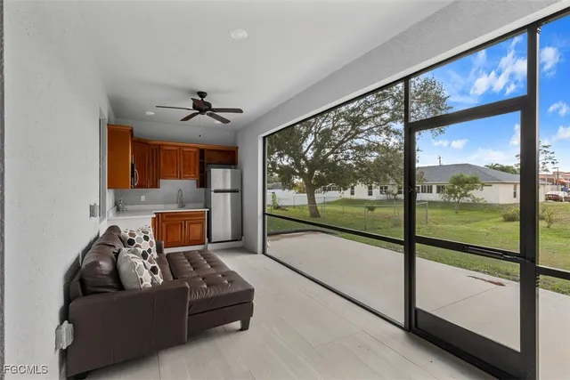 a living room with couch floor to ceiling window and a flat tv screen