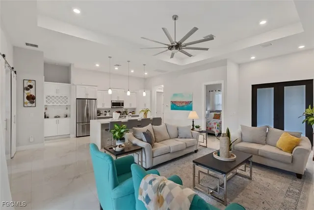 a living room with furniture kitchen view and a chandelier