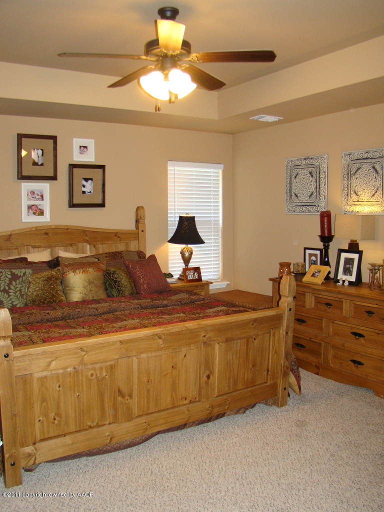 3715 Arden Road Amarillo, TX 79118 - Photo 14 of 24 a bed room with a bed and a chandelier
