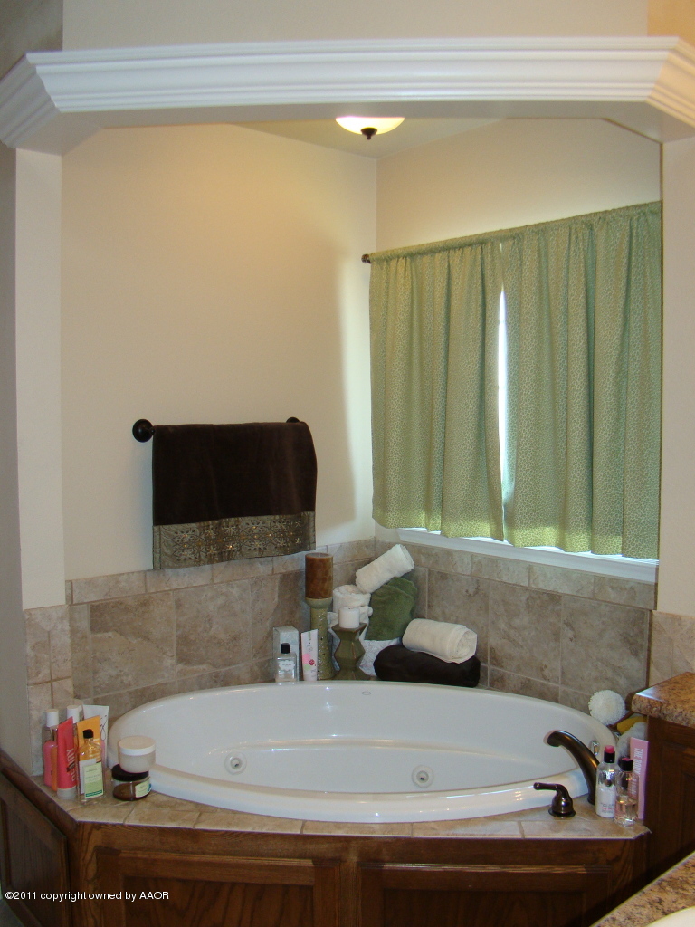 3715 Arden Road Amarillo, TX 79118 - Photo 18 of 24 a bathroom with a bathtub and a sink