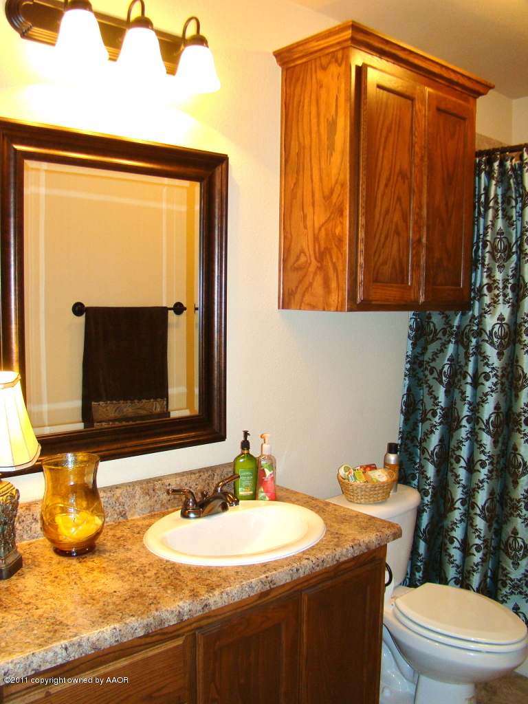 3715 Arden Road Amarillo, TX 79118 - Photo 22 of 24 a bathroom with a granite countertop sink and a mirror