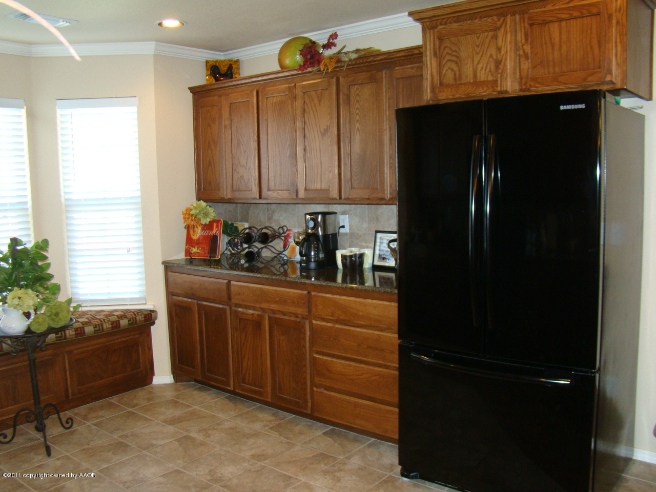 3715 Arden Road Amarillo, TX 79118 - Photo 8 of 24 a room with wooden cabinets and black appliances