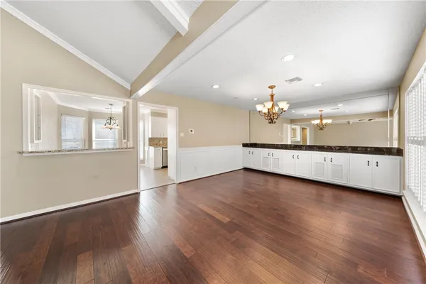 wooden floor in an empty room with a kitchen