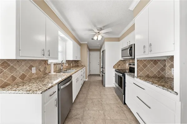 a kitchen with granite countertop white cabinets and white appliances