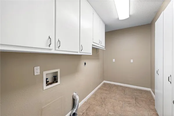 a kitchen with granite countertop white cabinets and a wooden floor
