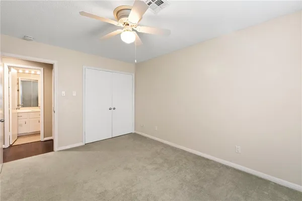 an empty room with a window and a ceiling fan