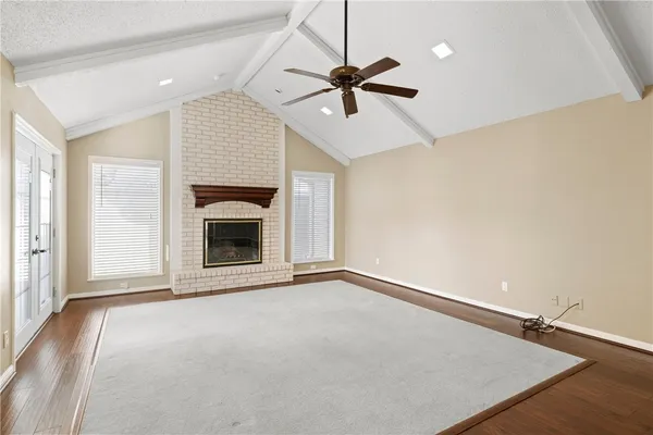 a view of an empty room with a fireplace and a window