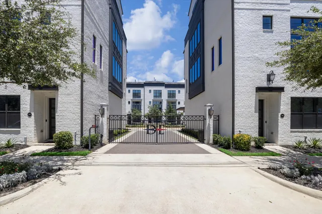 a view of a building with brick walls plants and large tree