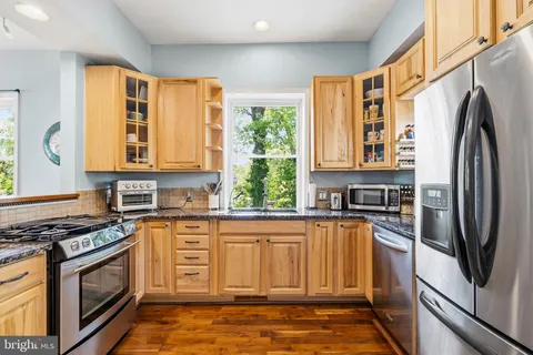 a kitchen with stainless steel appliances granite countertop a refrigerator and a stove top oven