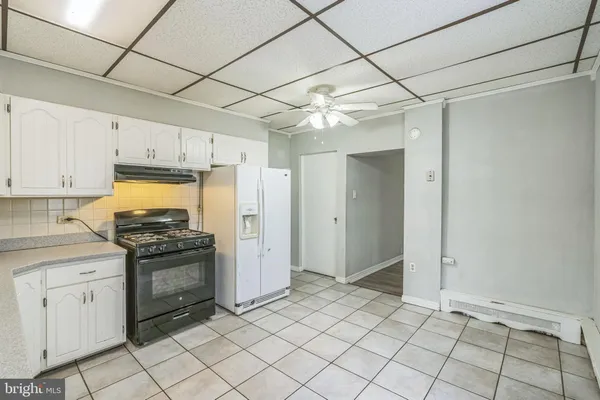a kitchen with white cabinets and appliances