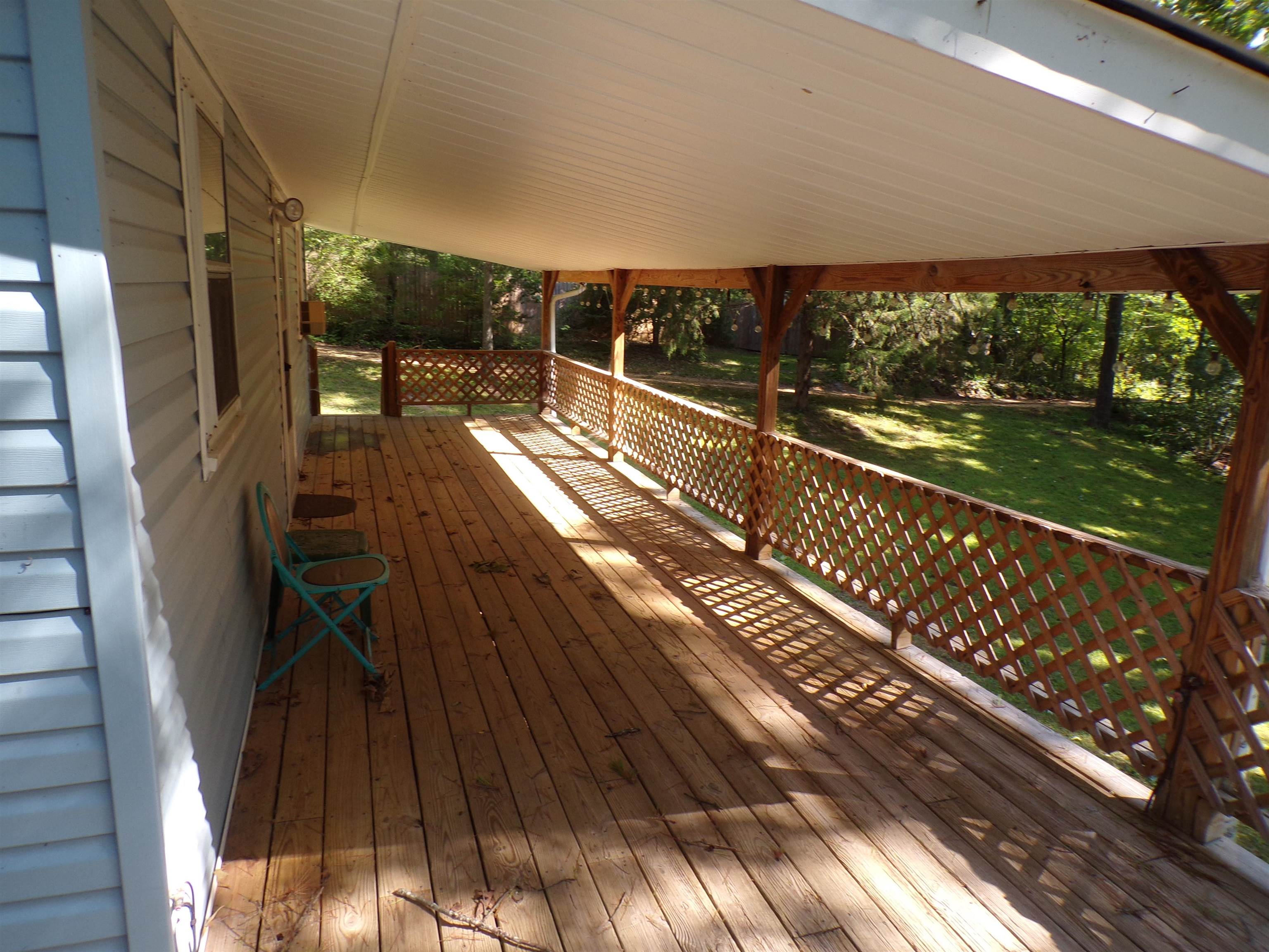 35 Cr 341 Road Iuka, MS 38852 - Photo 11 of 15 Expansive covered porch featuring wood flooring, wood lattice railings, and a white paneled ceiling