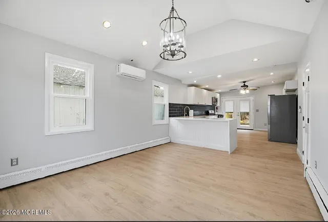 a view of a kitchen with a refrigerator wooden floor and a sink