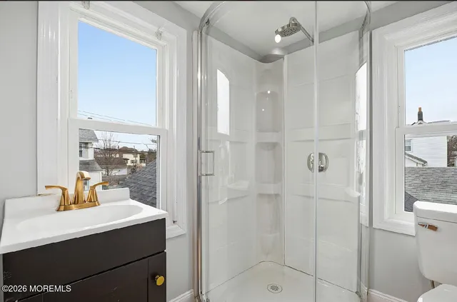 a bathroom with a shower sink and mirror