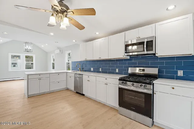 a kitchen with stainless steel appliances granite countertop a stove sink and cabinets