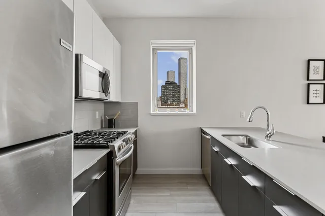 a kitchen with stainless steel appliances granite countertop a sink stove and cabinets