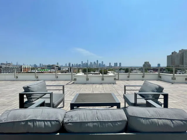 a view of roof deck with couches and city view
