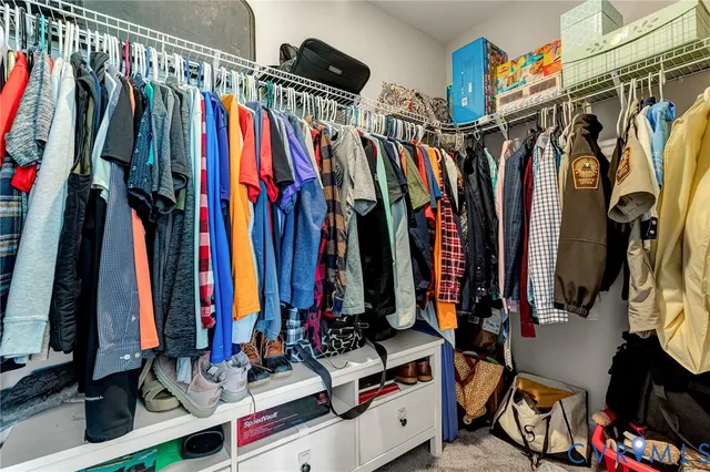 a view of walk in closet with clothes