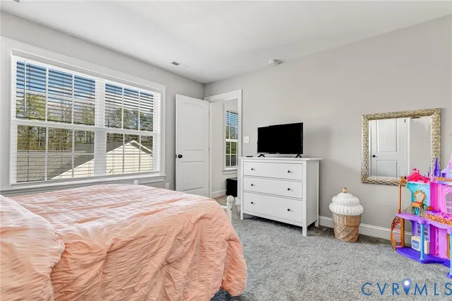 a bedroom with a bed and flat tv screen on the dresser