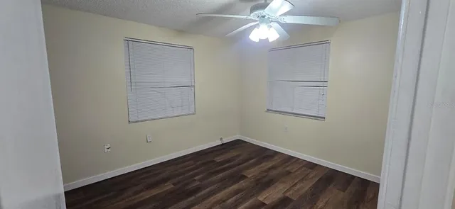 a view of a room with wooden floor and fan