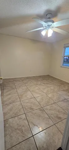 a view of an empty room with a chandelier fan
