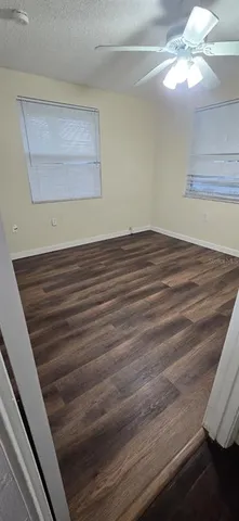 a view of a room with wooden floor and fan