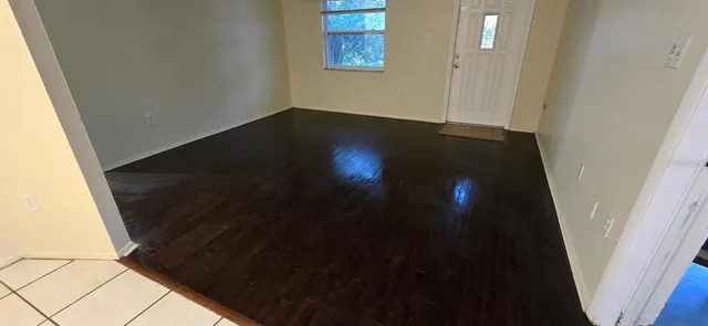 a view of empty room with wooden floor