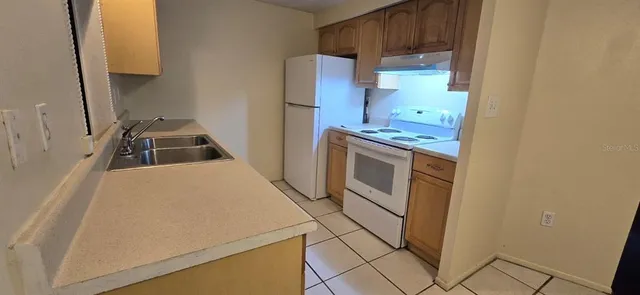 a kitchen with a stove a sink and a refrigerator