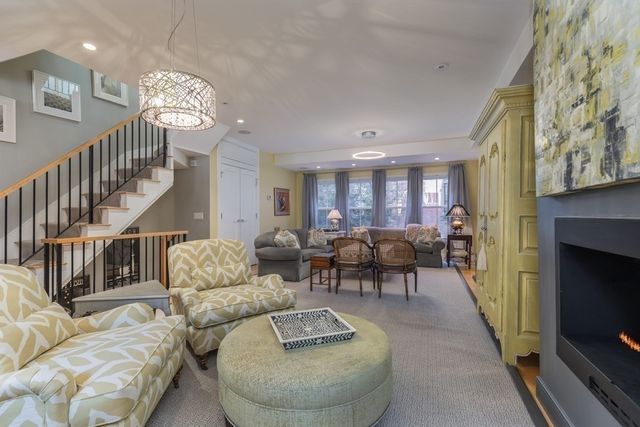 a living room with furniture chandelier and a fireplace