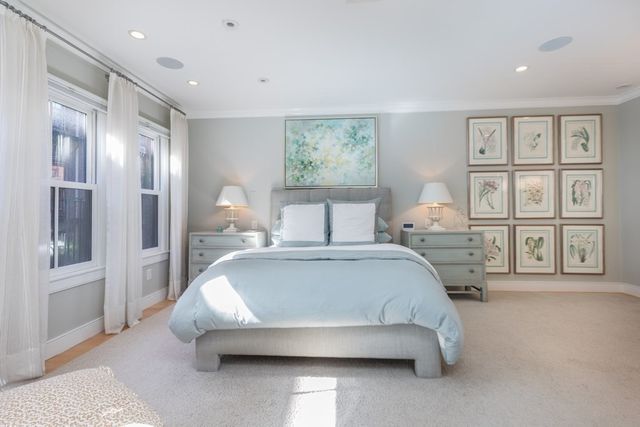 a bed room with a bed and three large window