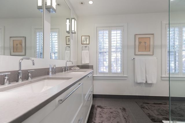 a bathroom with double vanity and a mirror
