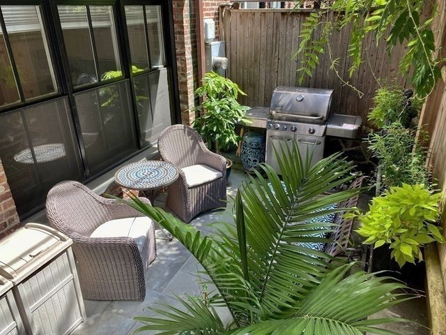 a view of a balcony with chairs and a potted plant