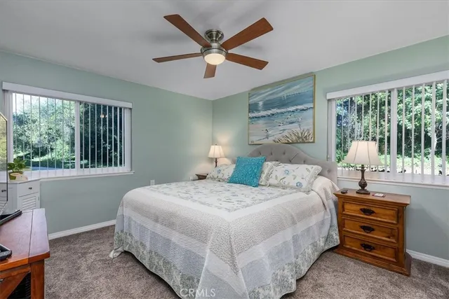 a bedroom with a bed a large window and a chandelier