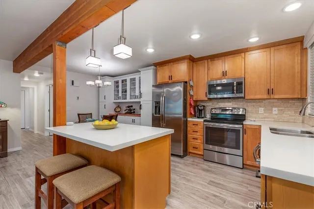 a kitchen with a refrigerator a stove top oven a sink dishwasher with wooden floor and cabinets