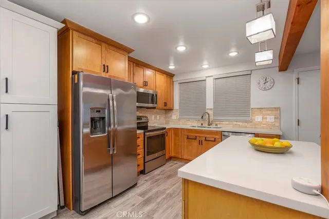a large kitchen with stainless steel appliances granite countertop a sink a stove and refrigerator