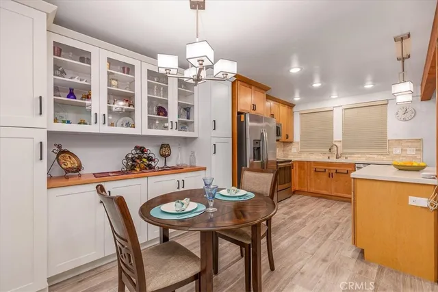 a view of a dining room and livingroom with furniture wooden floor a chandelier