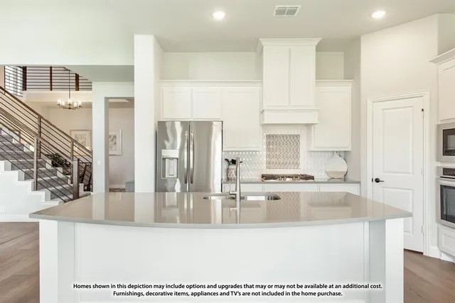 a large kitchen with stainless steel appliances granite countertop a sink a stove and refrigerator