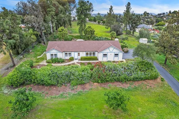 a house with green field in front of it