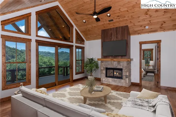 a living room with furniture a fireplace and a floor to ceiling window