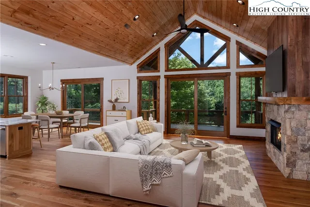 a living room with furniture a fireplace and a floor to ceiling window