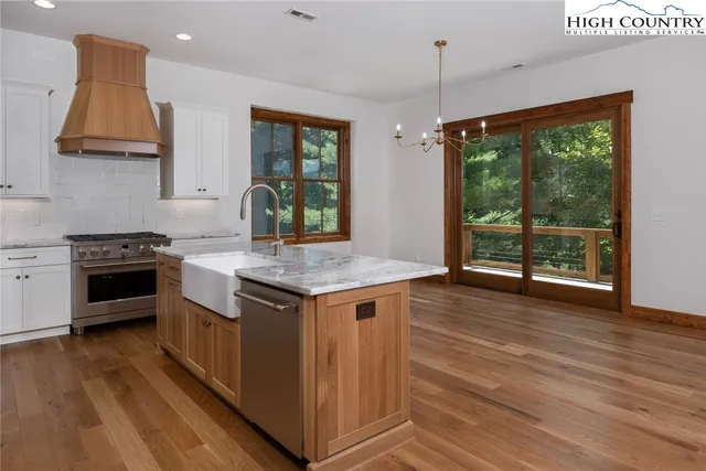 a kitchen with granite countertop a stove and a wooden floors
