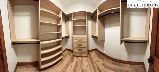 a view of walk in closet with empty racks