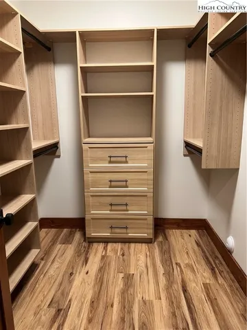 a view of walk in closet with empty racks