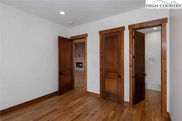 an empty room with wooden floor & closet area