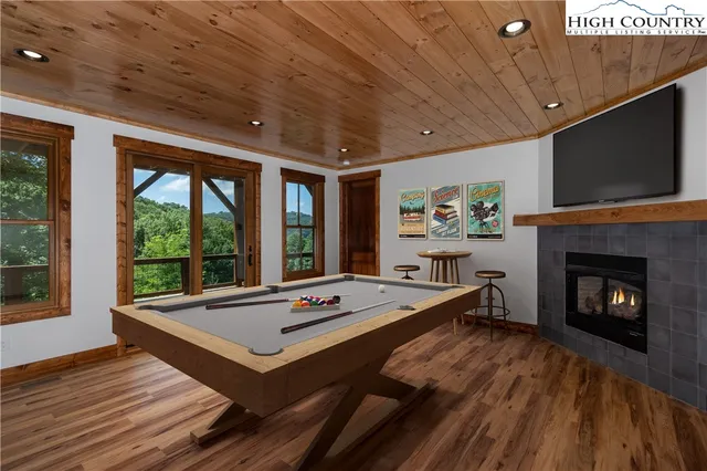 a room with furniture pool table flat screen tv and windows