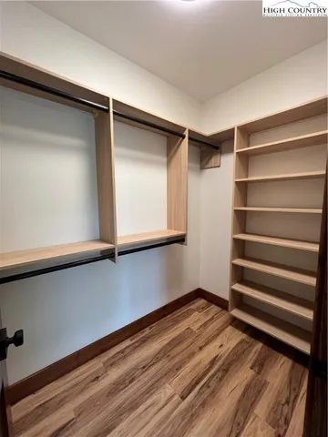 a view of walk in closet with empty racks
