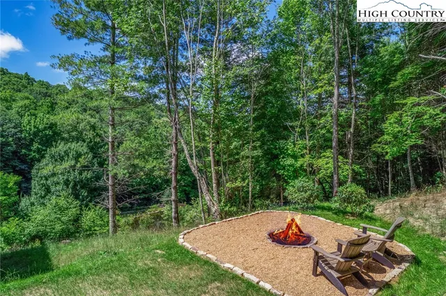 a view of a backyard with table and chairs and a fire pit