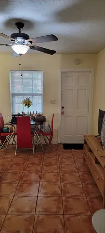 a living room with furniture a flat screen tv and a window