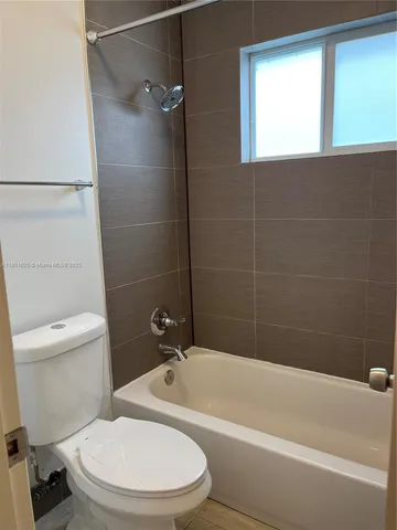 a white toilet and tub sitting next to a bathroom sink