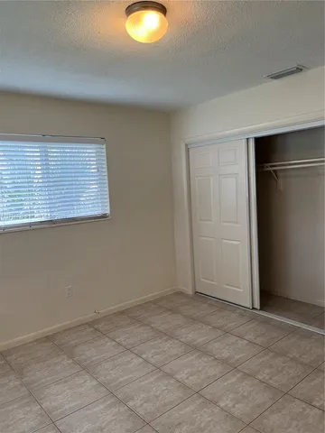 a view of an empty room with window and cabinet