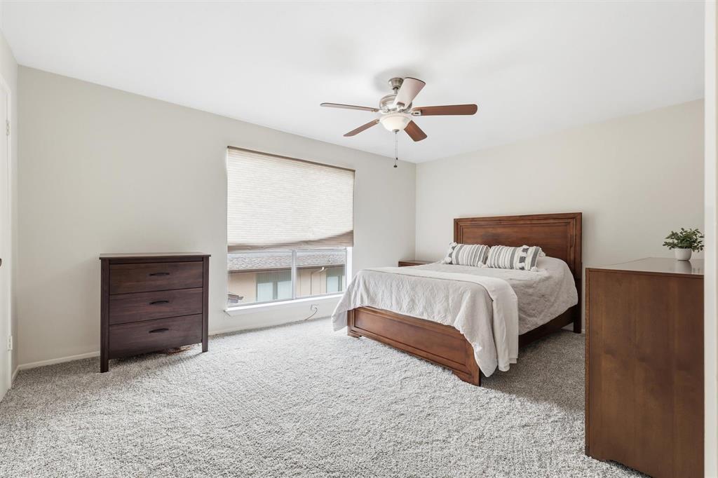 12818 Midway Road, Unit 2078 Dallas, TX 75244 - Photo 3 of 26 a bedroom with a bed and a ceiling fan